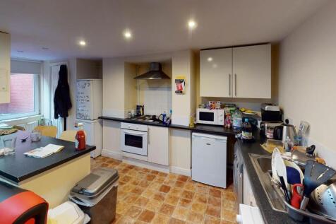 A well-equipped kitchen with white cabinets, a ...