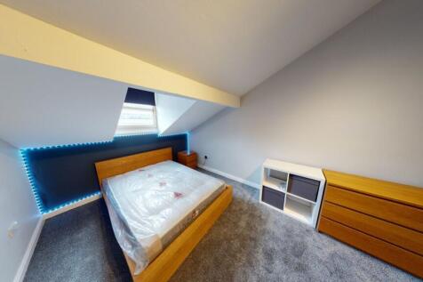 A spacious and modern master bedroom with a com...