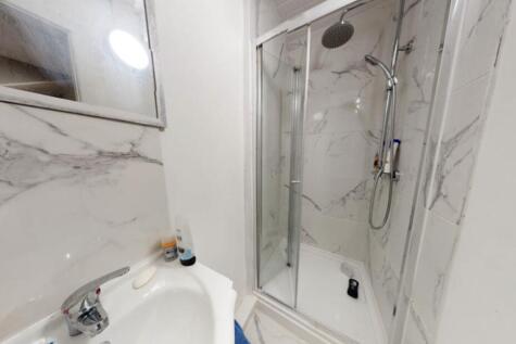 A modern bathroom featuring a large shower encl...