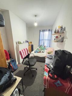 A well-kept bedroom featuring a single bed, a s...