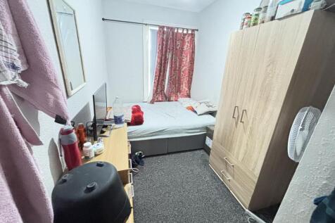 A well-lit, spacious double bedroom featuring a...