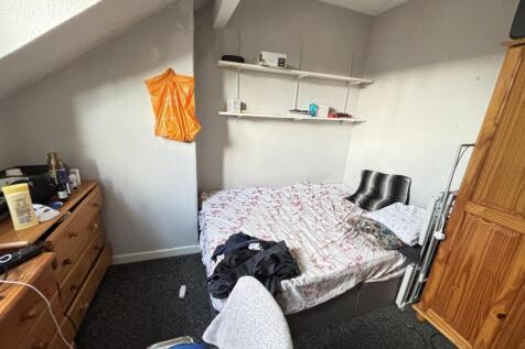 A cozy bedroom featuring a double bed with pill...