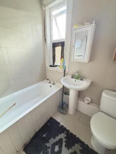 Bright and clean bathroom featuring a bathtub, ...