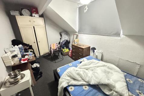 A cozy bedroom with a beds in place and a windo...