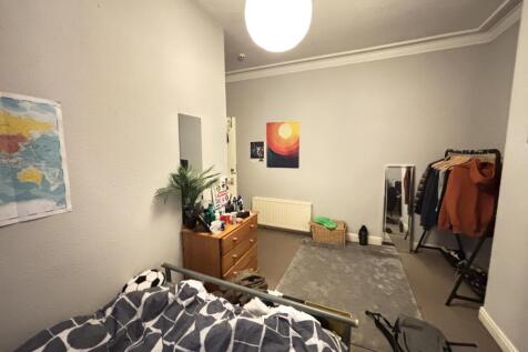 A tidy bedroom featuring a modern bed with a pa...