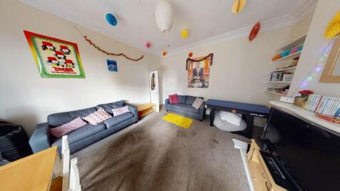 A spacious and well-lit living room featuring c...