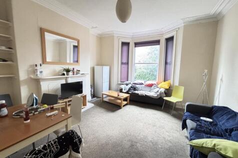 Bright and spacious living room featuring large...