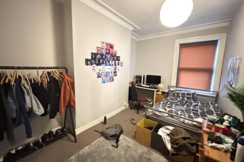 A cozy bedroom featuring a single bed with ampl...