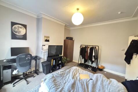 A comfortably furnished bedroom with a bed, a d...