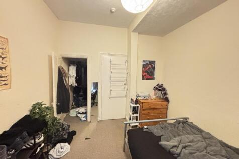 Cozy single bedroom with neutral walls, fitted ...