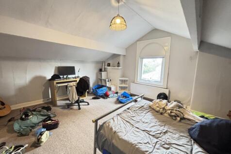 A cozy bedroom with a large window allowing nat...