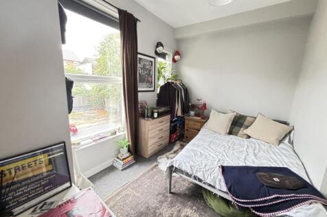 A well-lit spacious master bedroom featuring a ...