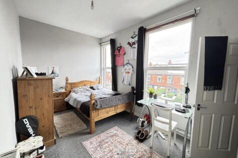 A bright, well-maintained bedroom featuring two...