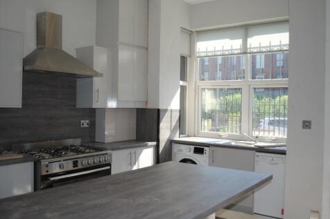 A bright and modern kitchen area with large win...