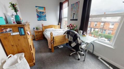 A cozy single bedroom with a comfortable bed, p...