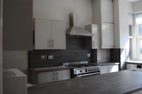 A modern and well-lit kitchen with sleek cabine...