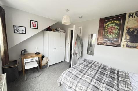 A tidy and well-lit bedroom featuring a comfort...