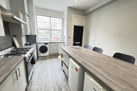 A modern kitchen with a cutting board on the is...