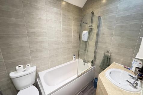 A modern and clean bathroom featuring a bathtub...