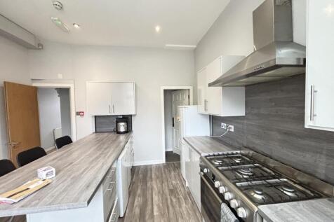 Modern kitchen with sleek white cabinets, a spa...