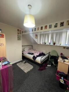 A cozy single bedroom featuring a metal bed fra...