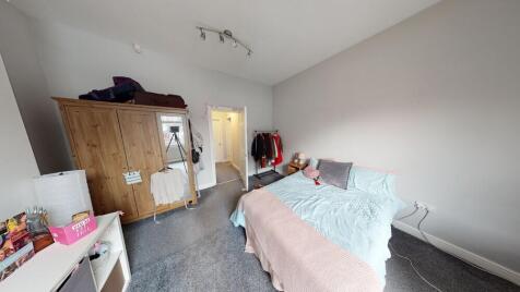 A cozy single bedroom with a comfortable bed, a...