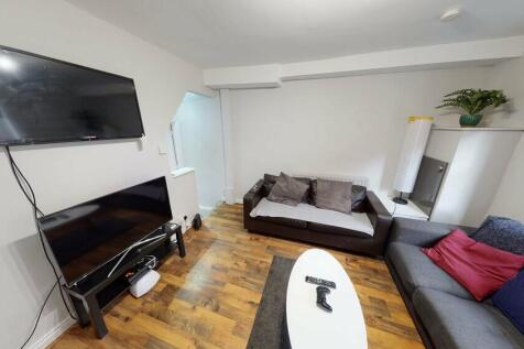 A spacious and well-lit living room featuring a...