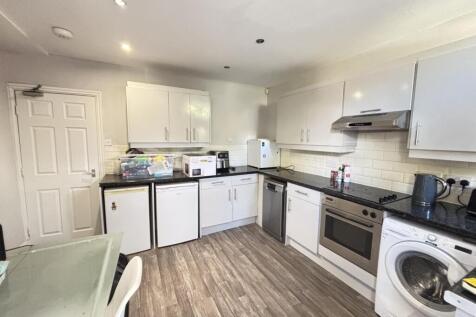 A modern, well-lit kitchen area featuring white...