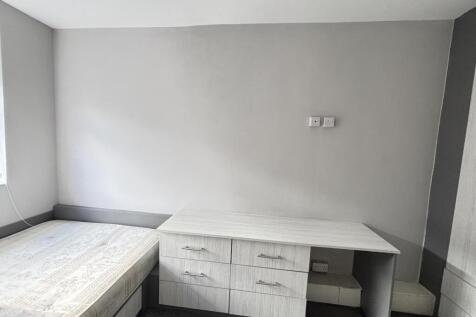 Bright, simply furnished bedroom with a built-i...