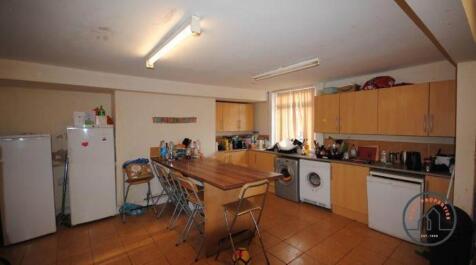 A well-lit, spacious kitchen area with wooden c...