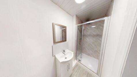 A clean, bright bathroom with a shower enclosur...