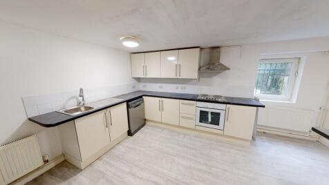 Bright, modern kitchen with cream cabinetry, in...