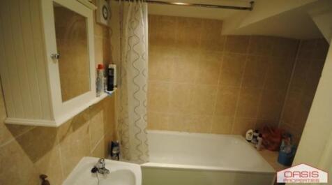 A clean and spacious bathroom featuring a batht...