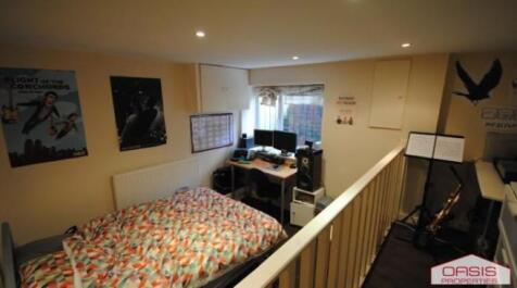 Well-lit bedroom featuring a comfortable double...