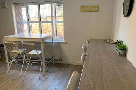 A bright and clean communal workspace with ampl...