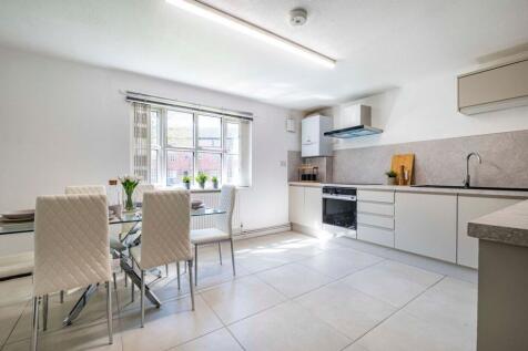Bright modern kitchen with a glass dining table...