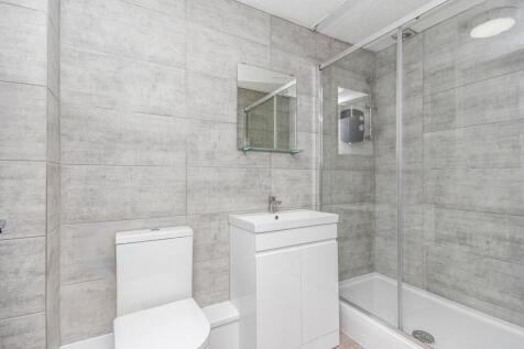 Modern tiled bathroom with a walk-in shower enc...