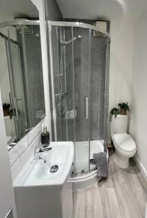 Modern, well-kept bathroom featuring a curved g...