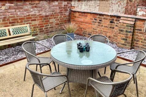Private paved courtyard with a round glass-top ...
