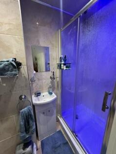 Compact modern bathroom with a corner sink and ...