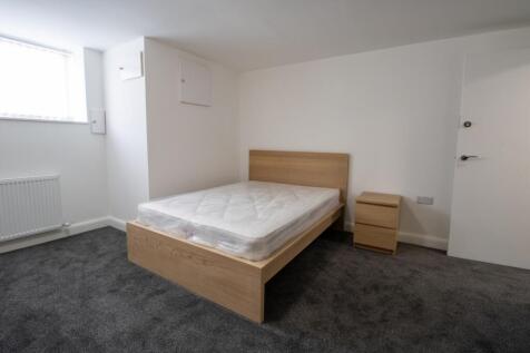Bright, simply furnished bedroom with a double ...