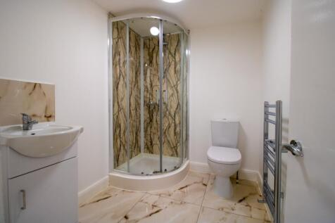 Bright, modern bathroom with a corner glass sho...