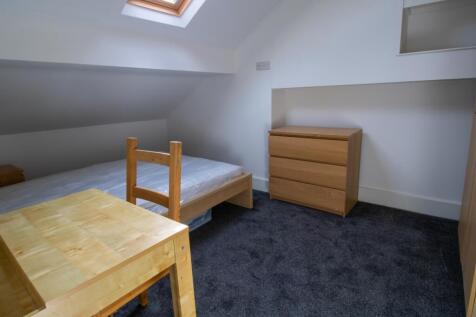 Neat attic single bedroom with a skylight bring...