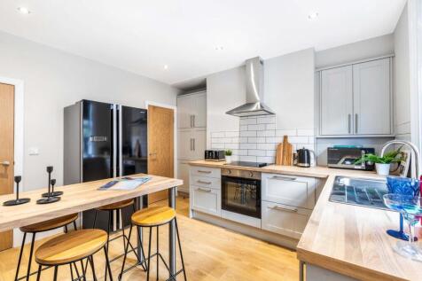 Bright, modern kitchen with light wood worktops...
