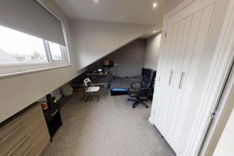 Bright upstairs single bedroom with a sloped ce...