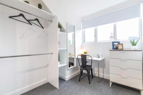 Bright, well-kept bedroom with a large window, ...