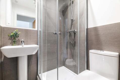 Bright, modern bathroom with a glass-enclosed s...