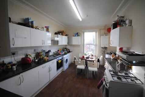 Bright galley kitchen with plenty of white cabi...