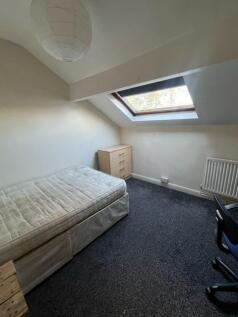 Cozy attic bedroom with a sloped ceiling, skyli...