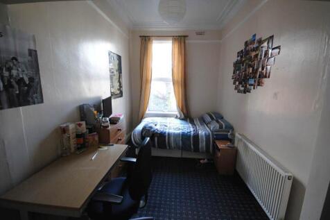 Cozy single bedroom with a neatly made bed, des...